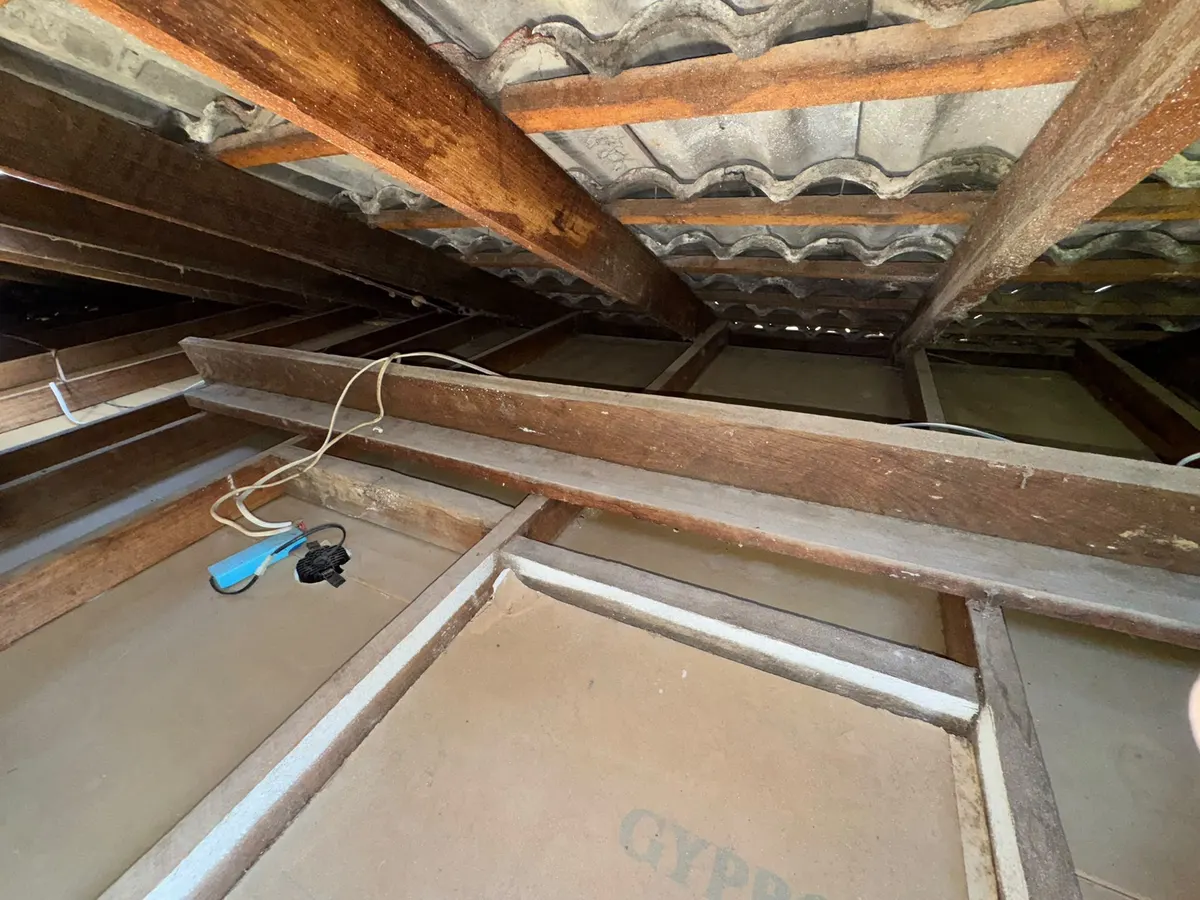 Roof cavity after vacuum removal, cleared down to the ceiling and joists (photo 1 of 7)