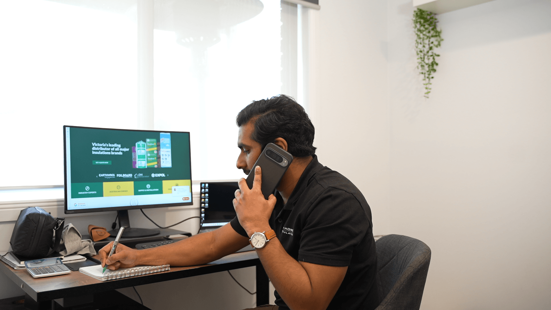 Oz Homes team member preparing a quote on the phone at the office